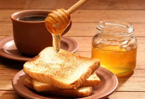Breakfast scene. Honey pouring over toast bread